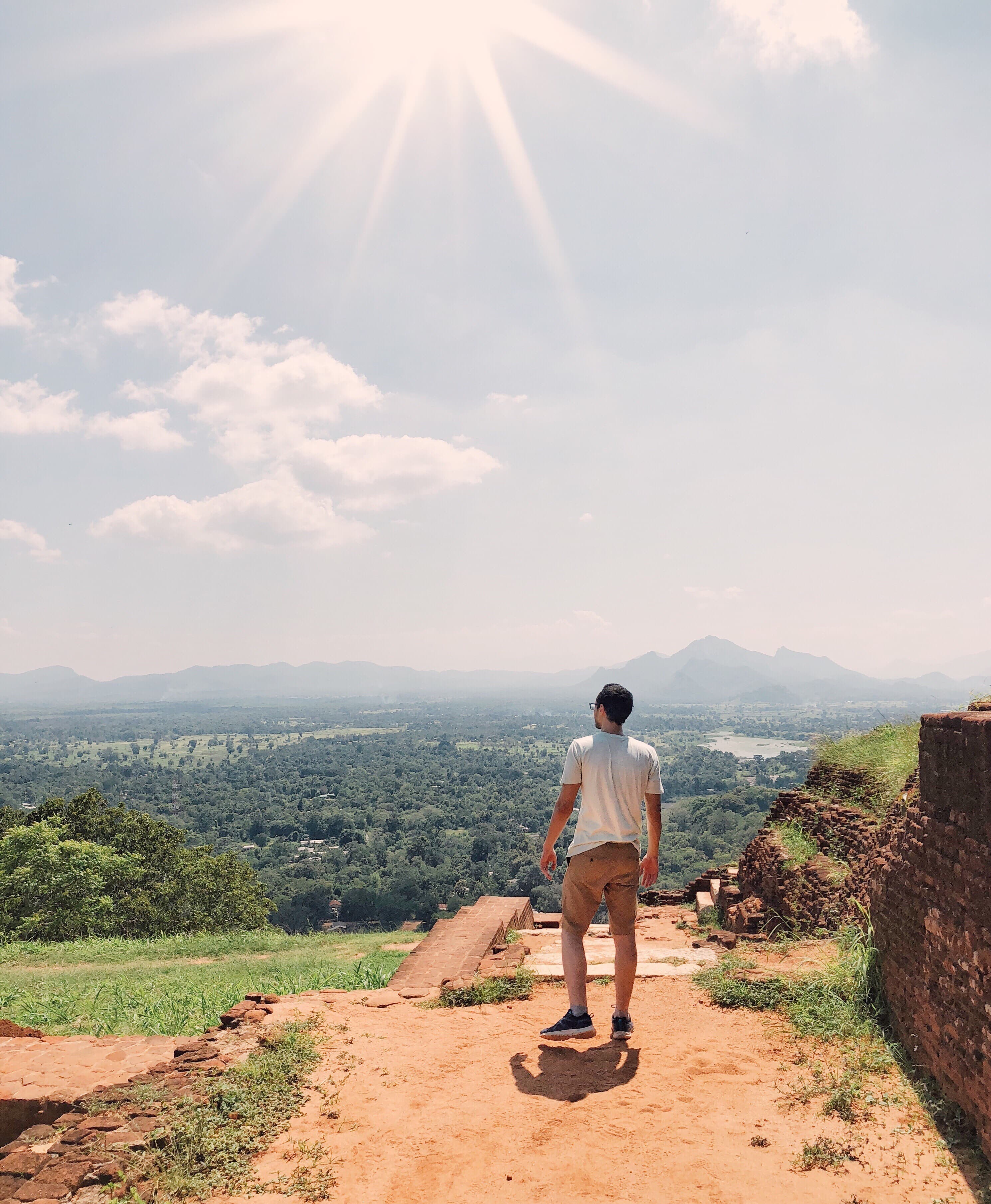 Traveler taking in a mountain and forest view from an ancient site
